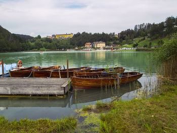 Boats moored in lake against sky