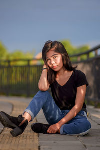 Portrait of young woman sitting on bench