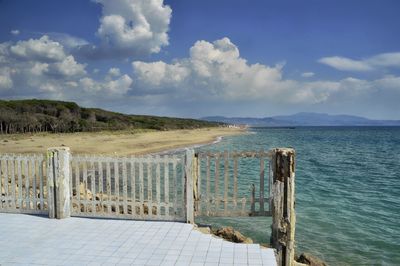 Wooden posts on the beach against sky