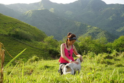 Woman with dog sitting on landscape