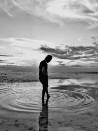 Full length of silhouette man standing on beach against sky