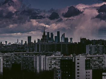 Modern buildings in city against sky during sunset