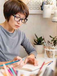 Woman is drawing in notebook. calming hobby, anti stress leisure. artist at work. cozy workplace.