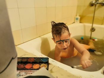 Portrait of shirtless boy in bathroom