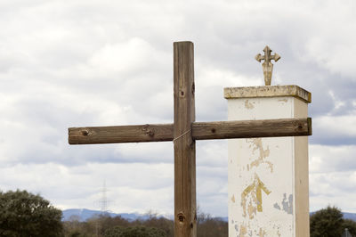 Close-up of cross sculpture against sky