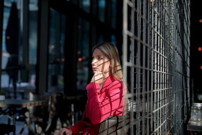 Portrait of young woman standing in city