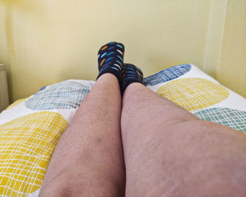 Low section of woman relaxing on bed