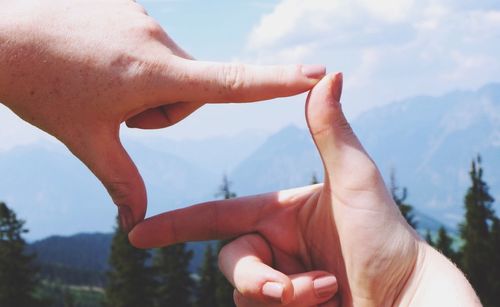 Close-up of cropped hand against clear sky