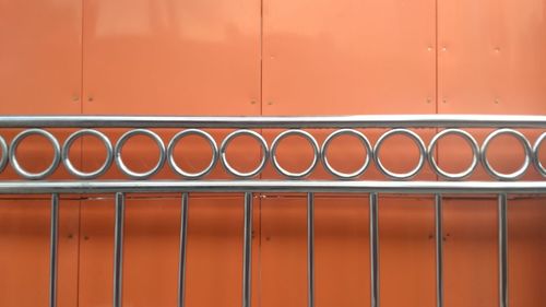 Full frame shot of railing against orange wall