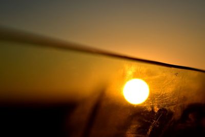 Close-up of illuminated lights against sky during sunset