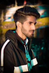 Portrait of young man looking away outdoors