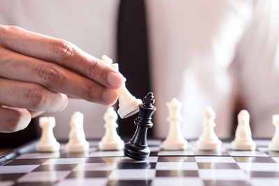 Midsection of businessman playing chess