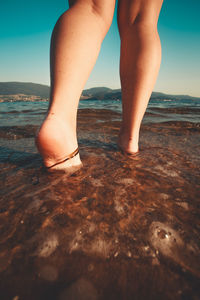 Low section of woman standing on beach