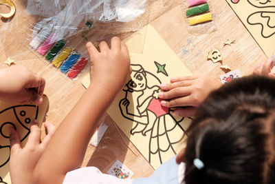 High angle view of children making card on table