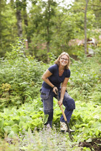 Smiling mature woman digging in garden