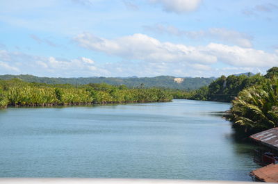 Scenic view of river against cloudy sky