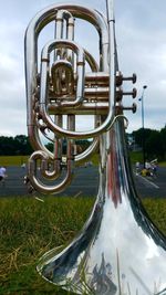 Large trumpet on field against sky