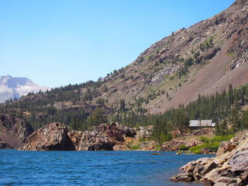 Scenic view of sea and mountains against clear sky