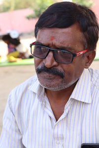 Close-up of mature man wearing eyeglasses outdoors