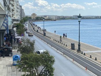 High angle view of vehicles on road by city against sky