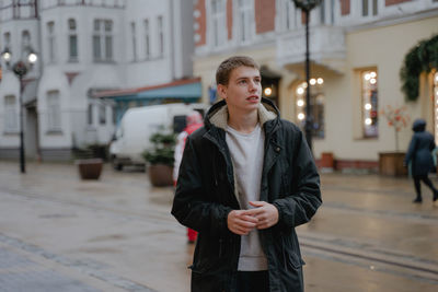 A young man with a questioning face, waiting for an answer, looks away