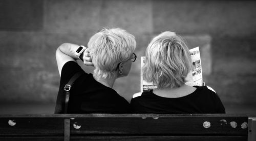 Rear view of people sitting on bench