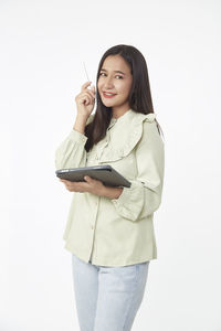 Portrait of a smiling young woman against white background