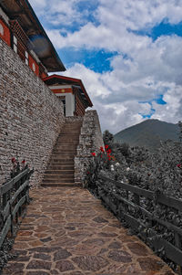 Staircase of building against cloudy sky