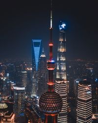 Illuminated buildings in city against sky at night