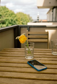 Flower vase on table against glass wall