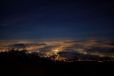 Aerial view of illuminated cityscape against sky at night