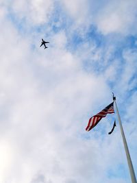 Low angle view of flag flying against sky