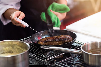 Midsection of person preparing food in kitchen