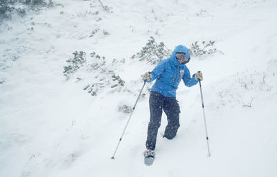 Woman hiking downhill on snowcapped mountain