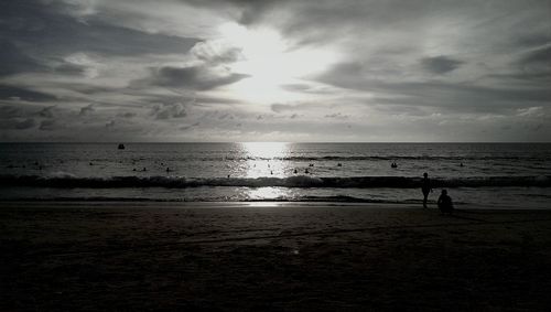 Scenic view of beach against cloudy sky