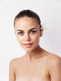 Portrait of young woman against white background