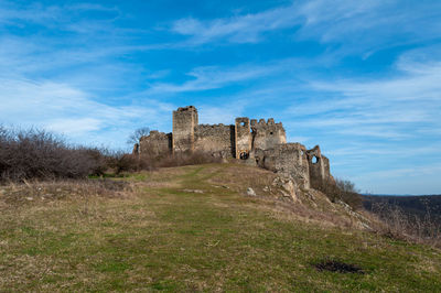 A view of soimos fortress with a blue sky in the background. built in 1278