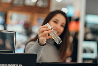 Midsection of woman using mobile phone in cafe