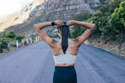 Rear view of woman exercising on road