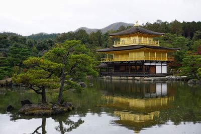 Built structure by lake against sky