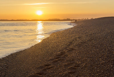 Scenic view of beach against sky during sunset