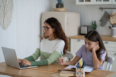 Side view of young businesswoman working on table