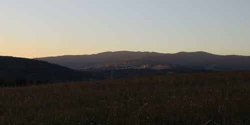 Scenic view of field against clear sky during sunset