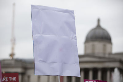 Close-up of hand holding placard against blurred background