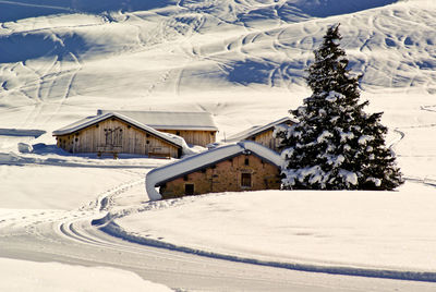 Snow covered field against sky during winter