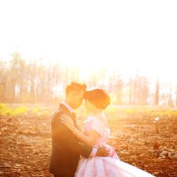 Couple kissing on field against sky