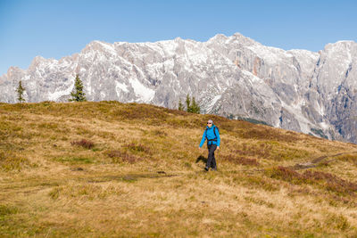 Woman hiking on footpath in alpine landscape, hochkönig, austria.