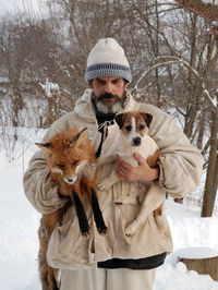 Man holding fox and dog