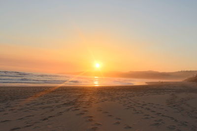 Scenic view of beach against sky during sunset