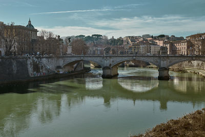 Bridge over river with city in background